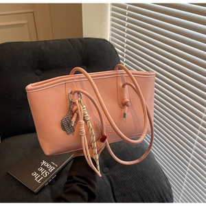 Close-up of pink leather bucket bag with abacus charm and braided rope detail
