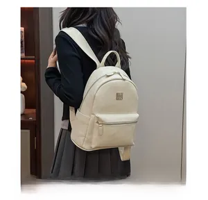 Detail view of the beige PU leather backpack featuring golden hardware and front pocket