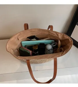 Large straw tote bag showing spacious interior with tablet, phone, and daily essentials