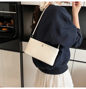 Dettaglio della borsa a tracolla in pelle bianca con logo H argento e perla nera decorativa