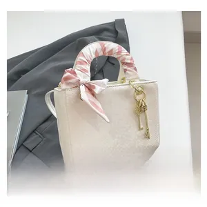 Détail macro de la texture serpent blanc du petit sac avec poignée en foulard de soie