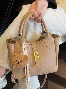Beige lychee pattern bucket bag with bear charm and golden twist lock detail