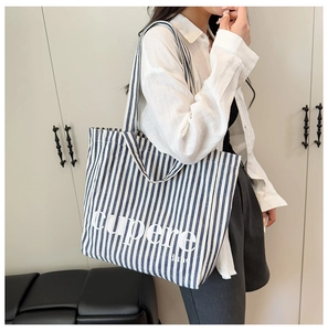Close-up of blue striped canvas tote bag with white cupere lettering for daily casual use