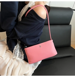 Dettaglio borsa baguette in pelle rosa con logo H in metallo argentato e tracolla sottile