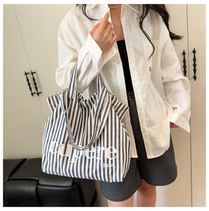 Detail shot of the blue and white striped canvas tote bag with printed lettering