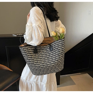 Detail of black and white geometric woven tote bag with premium leather shoulder straps