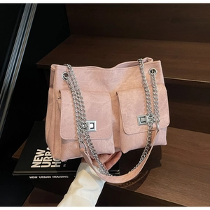 Détail du cabas rose en cuir texturé avec deux poches avant et bandoulière en chaîne