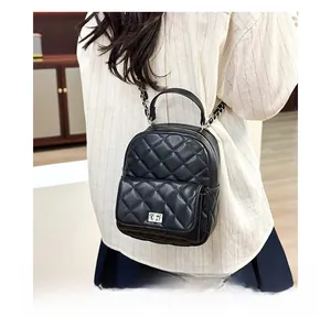 Close-up of black quilted mini backpack featuring chain straps and silver twist lock