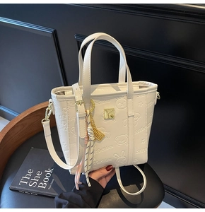Detailed macro view of white synthetic leather bucket bag with cute embossed cartoon patterns