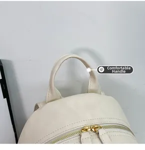 Detail of minimalist beige faux leather backpack showing comfortable handle and golden zipper