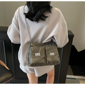 Détail du sac bandoulière gris vintage avec deux poches à rabat et verrous tournants argentés