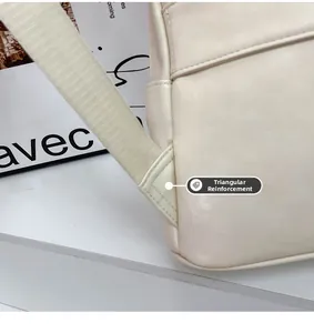 Detail of the triangular reinforcement stitching on cream PU leather backpack straps