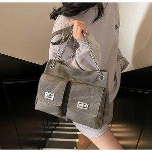 Détail du sac cabas en jean délavé vintage avec chaînes argentées et fermoirs rotatifs en métal