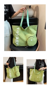 Détail du sac fourre-tout en toile lavée vert clair avec texte voyage et petite pochette