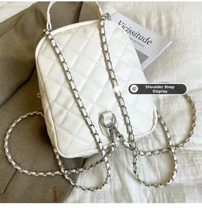 Detailed view of the creamy white quilted faux leather texture and elegant chain straps