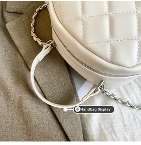 Detail display of the cream quilted leather bag featuring a silver woven chain and handle