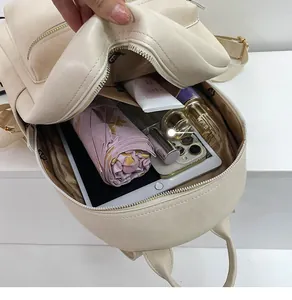 Interior view showing the large capacity and storage of the cream PU leather backpack
