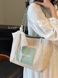 Straw woven tote bag with green accents, white lace bow, and Summer text for beach vacation