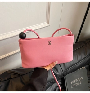 Dettaglio della borsa in pelle rosa con fibbia a H argentata e grandi perle nere decorative