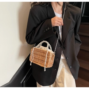 Detail of woven straw bag with pearl ring handle, inner drawstring and metal chain strap