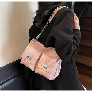 Détail du sac cabas en daim rose avec poches avant et fermoirs rotatifs en métal argenté