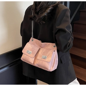 Détail du sac rose montrant deux poches avant avec d'élégants fermoirs rotatifs en métal