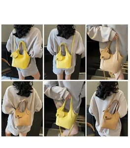 Litchi texture mini handbag with elephant charm shown in multiple carrying styles