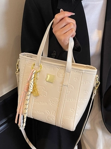 Beige embossed bucket bag with cute bear patterns and gold hardware detail for women