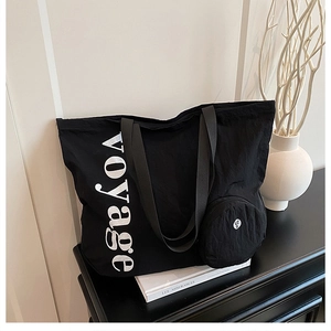 Détail du sac cabas noir en toile avec imprimé voyage et un petit porte-monnaie circulaire
