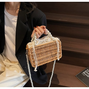 Detailed macro view of retro woven handbag with large pearl handle and crossbody strap