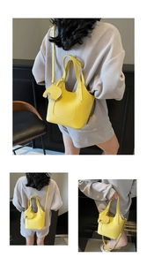 Detail of yellow lychee grain leather handbag with adjustable strap and elephant charm