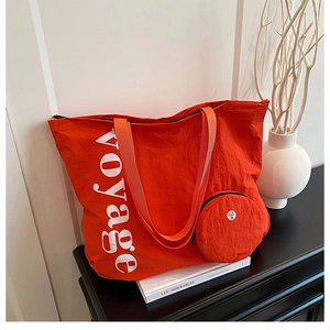 Détail du grand sac cabas orange en toile lavée avec texte voyage et pochette ronde