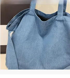 Detailed macro view of light blue denim canvas tote bag with diagonal twill texture