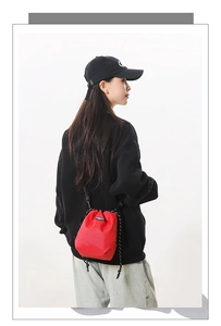 Detailed back view of a woman wearing the red nylon drawstring bucket bag with grid texture