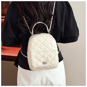 Detailed back view of white quilted faux leather backpack with silver turn-lock and chain straps