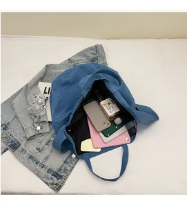 Macro shot showing blue denim tote interior with smartphone and tablet storage