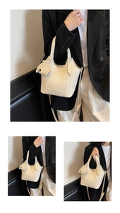 Detailed view of a white pebble leather bucket bag featuring an elephant charm and strap