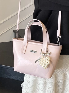 Pink minimalist bucket bag with pearl heart charm and crossbody strap for women