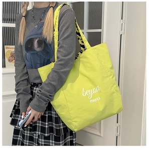 Detail of neon yellow tote bag with beyou merci print and leopard print lining