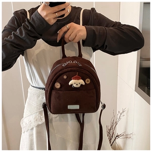 Dettaglio mini zaino retrò marrone caffè con ciondolo a cucciolo e finitura in pelle scamosciata