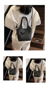Detail view of black litchi texture bucket bag featuring a cute elephant leather charm