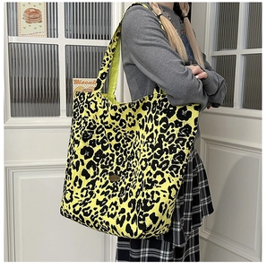 Macro view of leopard print canvas tote bag with long strap on casual shoulder carry