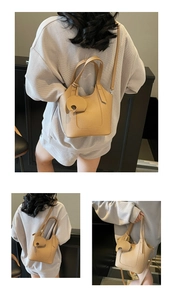 Detail of lychee pattern leather bucket bag with a cute elephant charm accessory