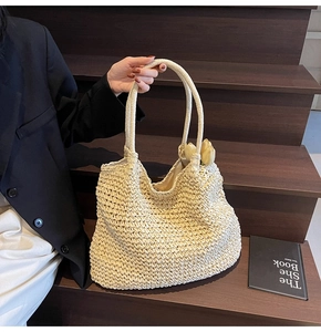 Detail of hand-woven beige straw bucket bag with floral interior for summer beach