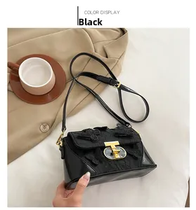 Detail of elegant black crossbody bag with 3D butterfly embroidery and gold metal clasp