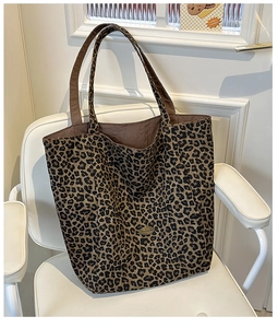 Detailed view of large leopard print tote bag featuring a handmade leather patch and lining