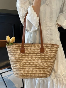 Large pastoral straw tote bag with brown leather handles and geometric woven patterns