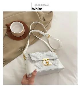 Detailed macro shot of white crossbody bag with 3D butterfly lace embroidery and gold lock
