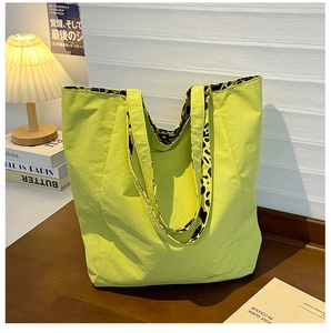 Detail showing the lime green tote bag with leopard print lining on wooden tabletop