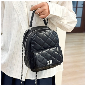 Detail of black quilted leather mini backpack with silver twist lock and chain strap